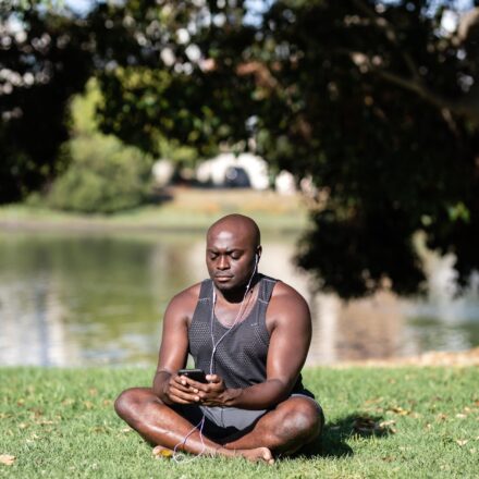 person meditating with phone in background
