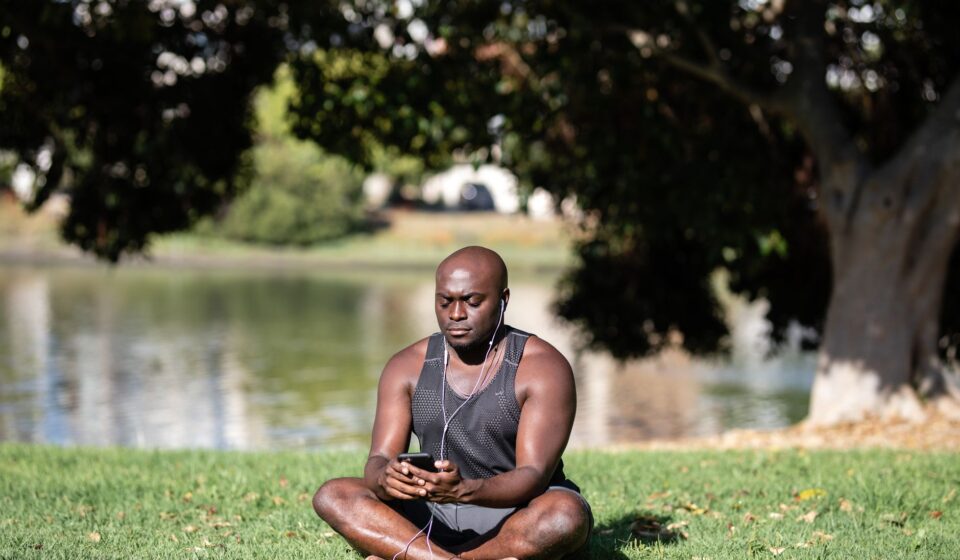 person meditating with phone in background