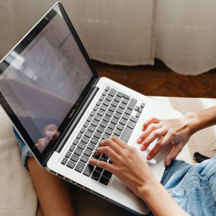 person writing enthusiastically on laptop