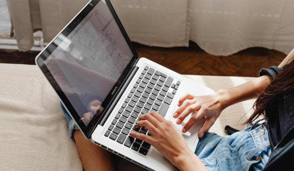 person writing enthusiastically on laptop